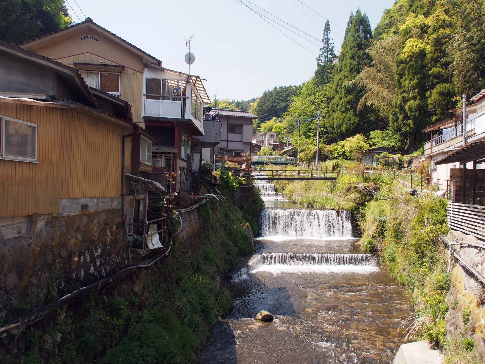 湯平溫泉街沿花合野川而建的旅館與瀑流景色