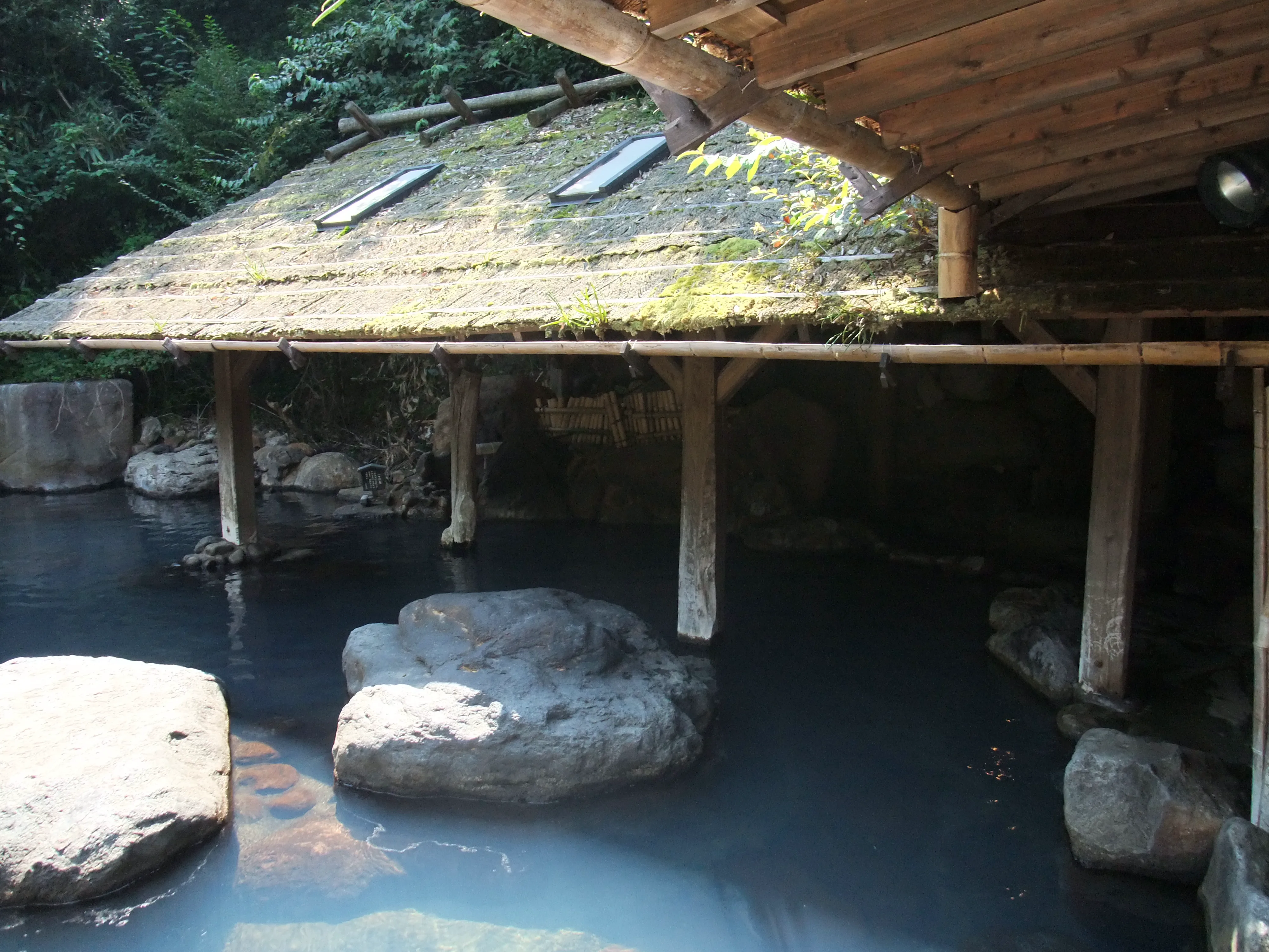 黑川溫泉露天岩浴池實景,池水沿天然岩石邊緣流動